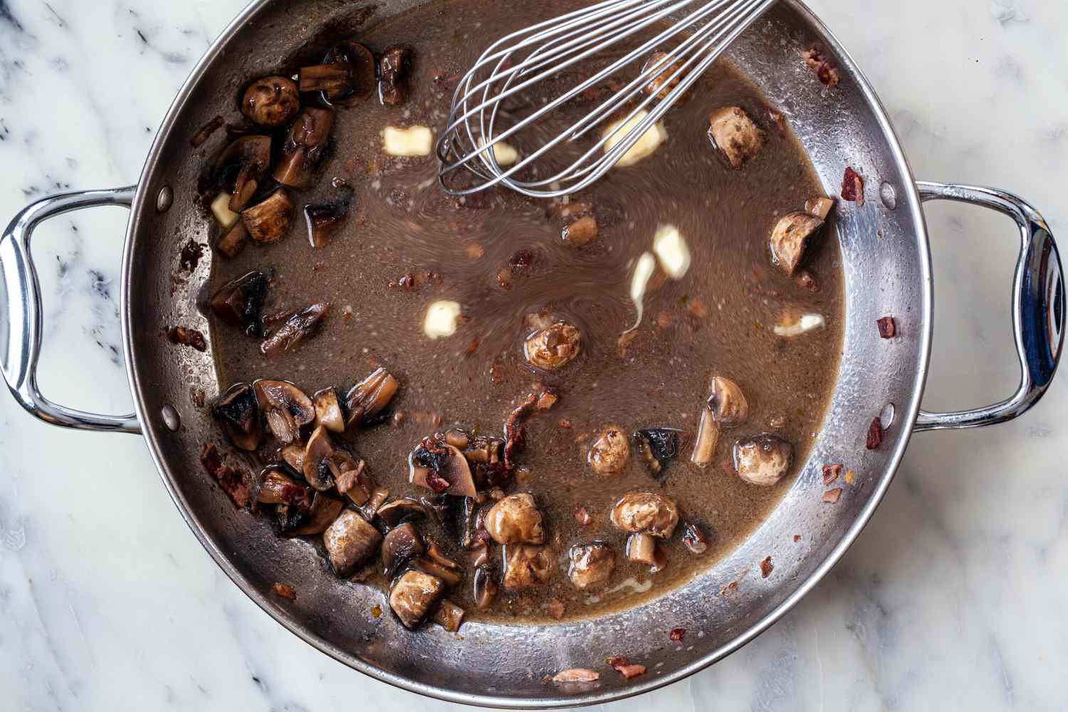 Whisking coq au vin sauce.