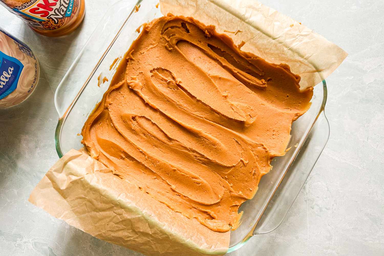 Peanut butter fudge spread into a glass baking dish for 2-ingredient peanut butter fudge recipe