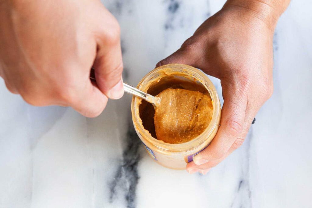 Stirring natural peanut butter after upside down method