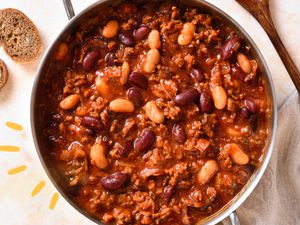 Photo of a pot of chili with yellow lined illustrations next to it