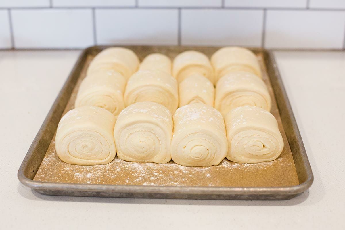 Formed lion house roll recipe set on a baking sheet and rising.