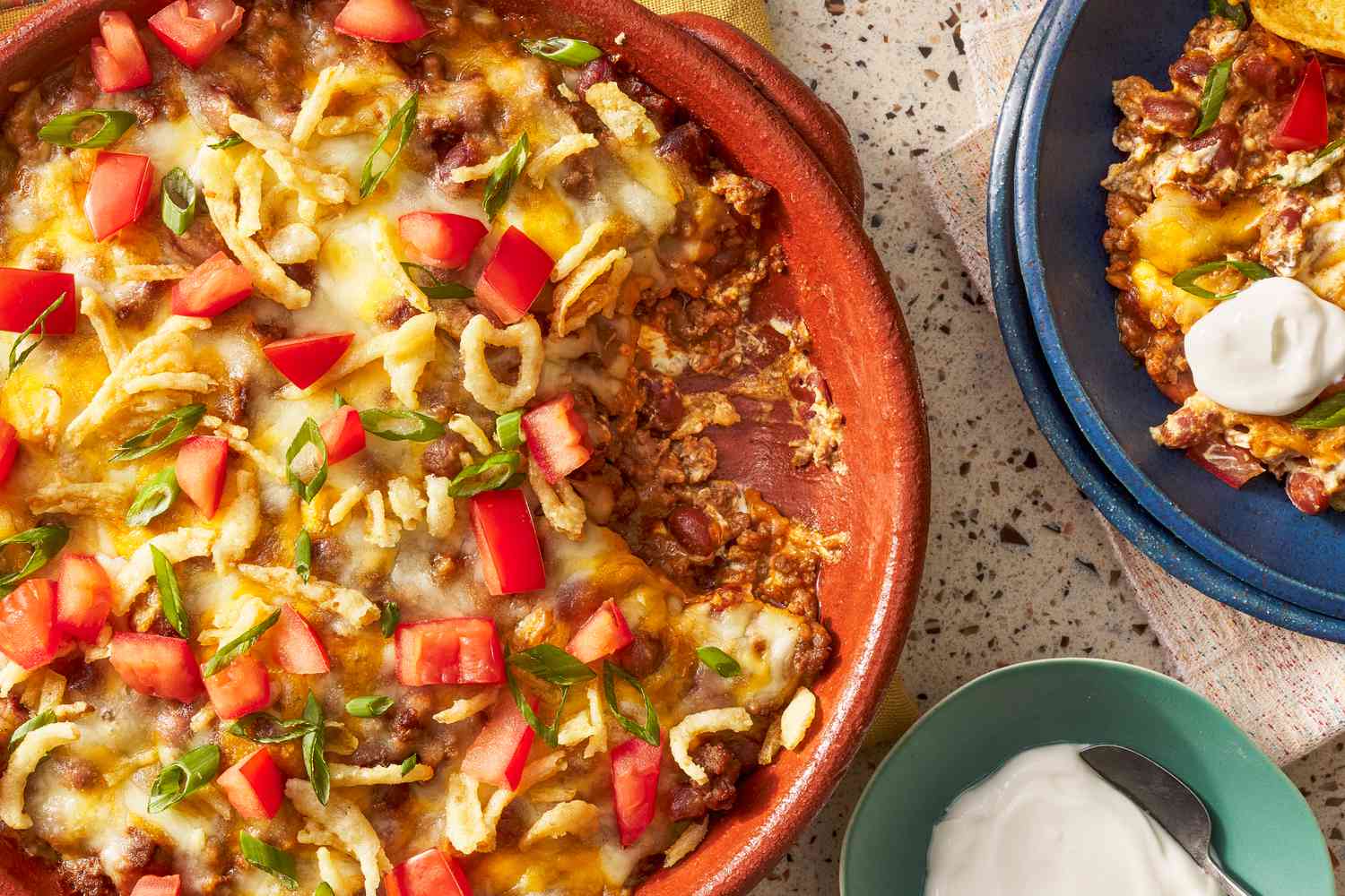 Bowl of chili dip with a serving in a bowl next to it 