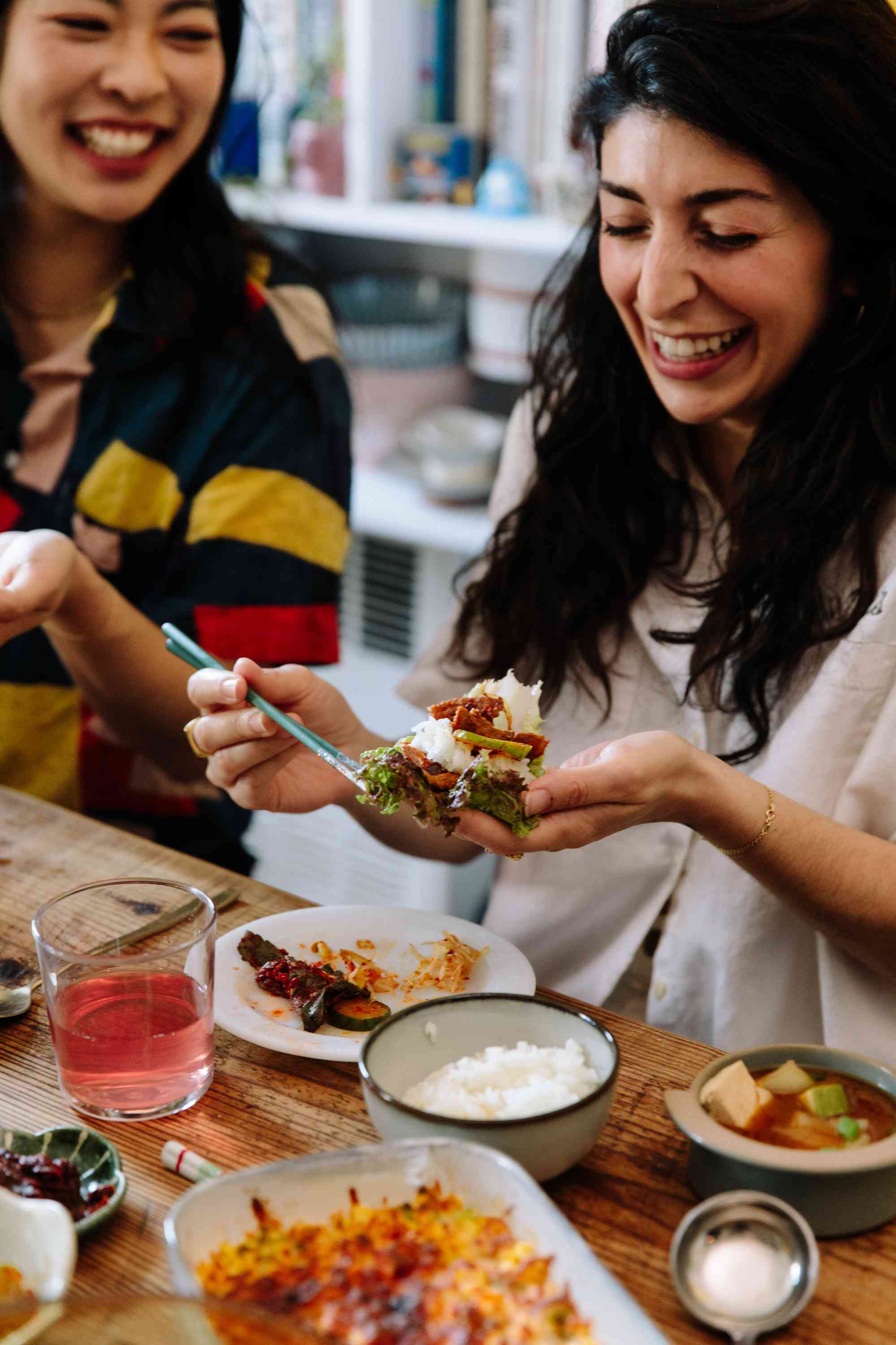 A women assembling Korean BBQ and toppings on a lettuce leaf