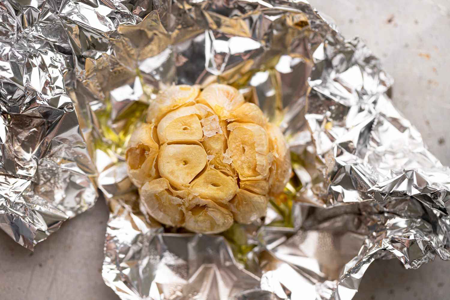 A roasted head of garlic in foil to make a garlic mashed potatoes recipe.