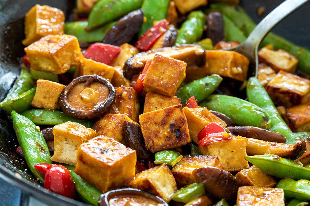 Tofu and vegetables mixed with sauce in a wok to make a Healthy Stir Fry.