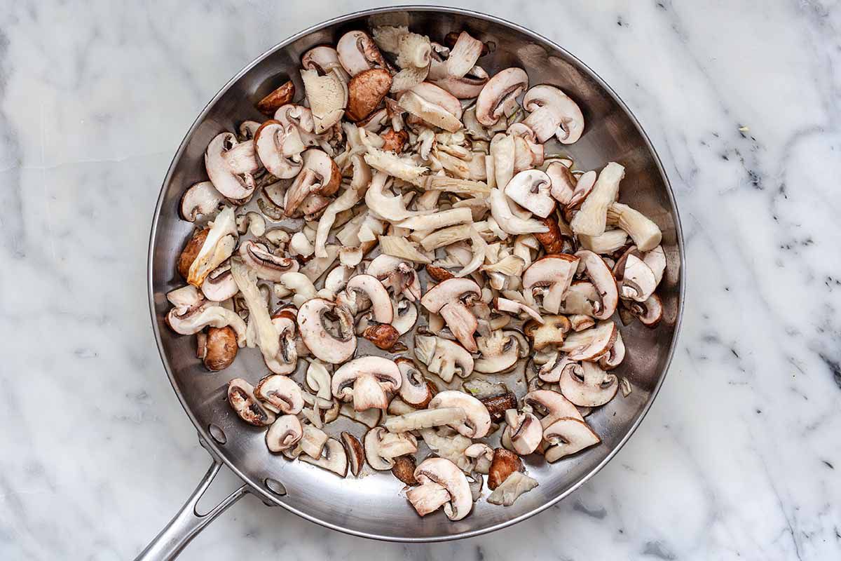 How to Make Quesadillas Vegetarian -- silver pan with raw mushrooms about to be cooked