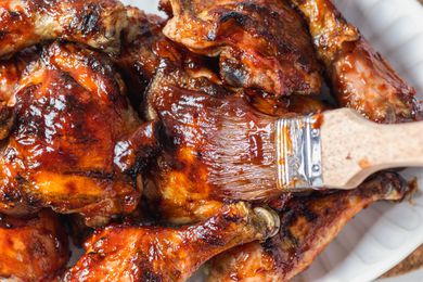 Brushing bbq sauce on barbecue chicken.