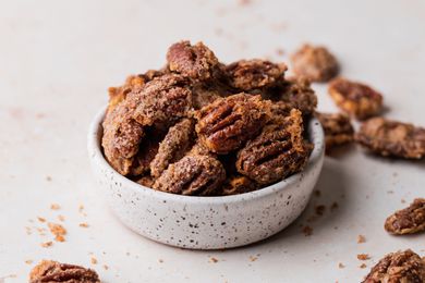 Side view of a bowl of candied pecans.