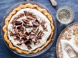 A whole chocolate pie topped with shaved chocolate.