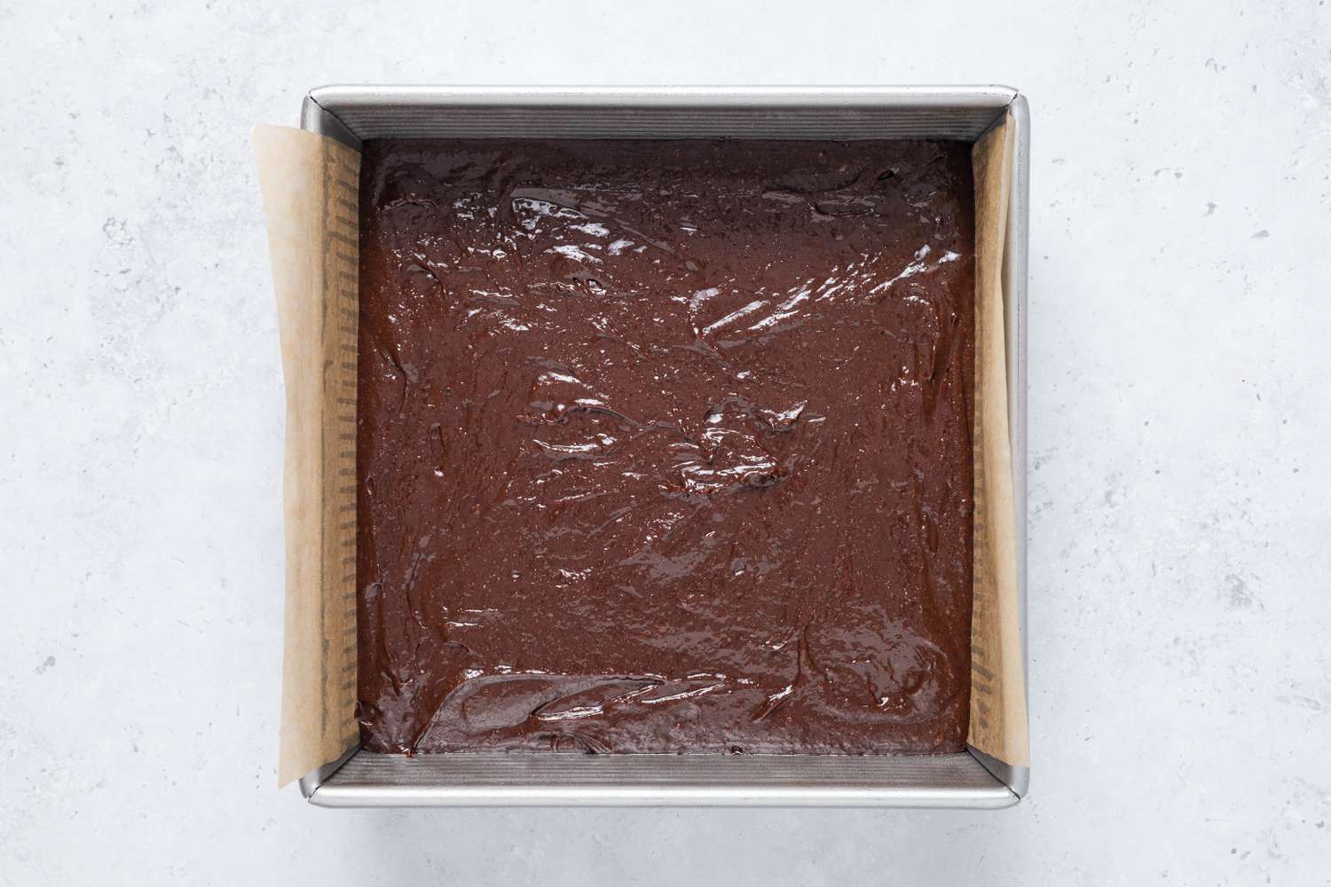 Homemade Cosmic Brownie batter in a lined baking pan