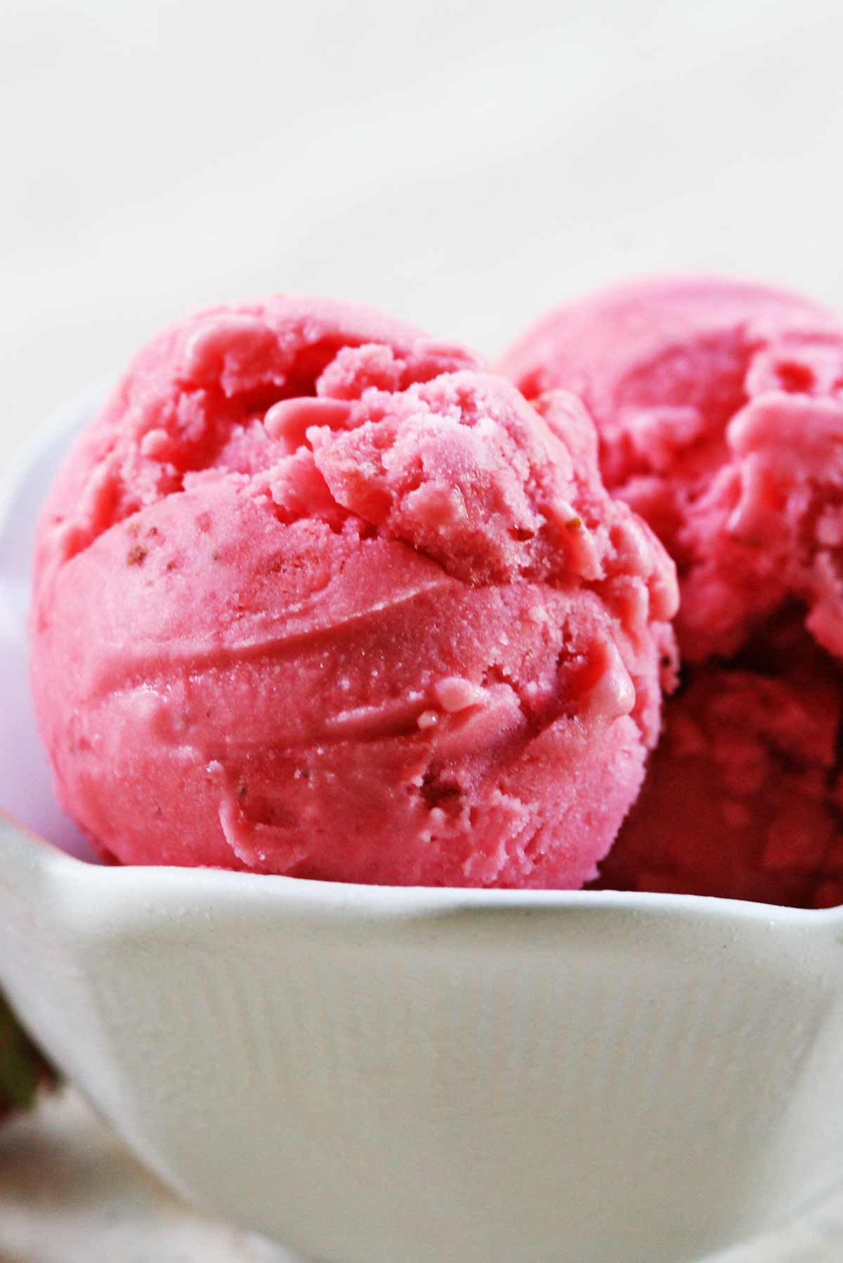 Scoops of strawberry frozen yogurt in a bowl