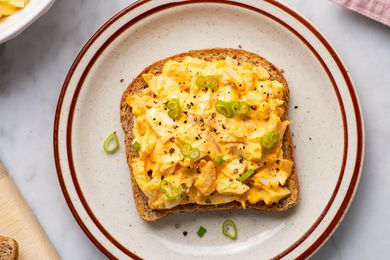 Overhead view of a toast topped with kimchi egg salad and sliced scallions