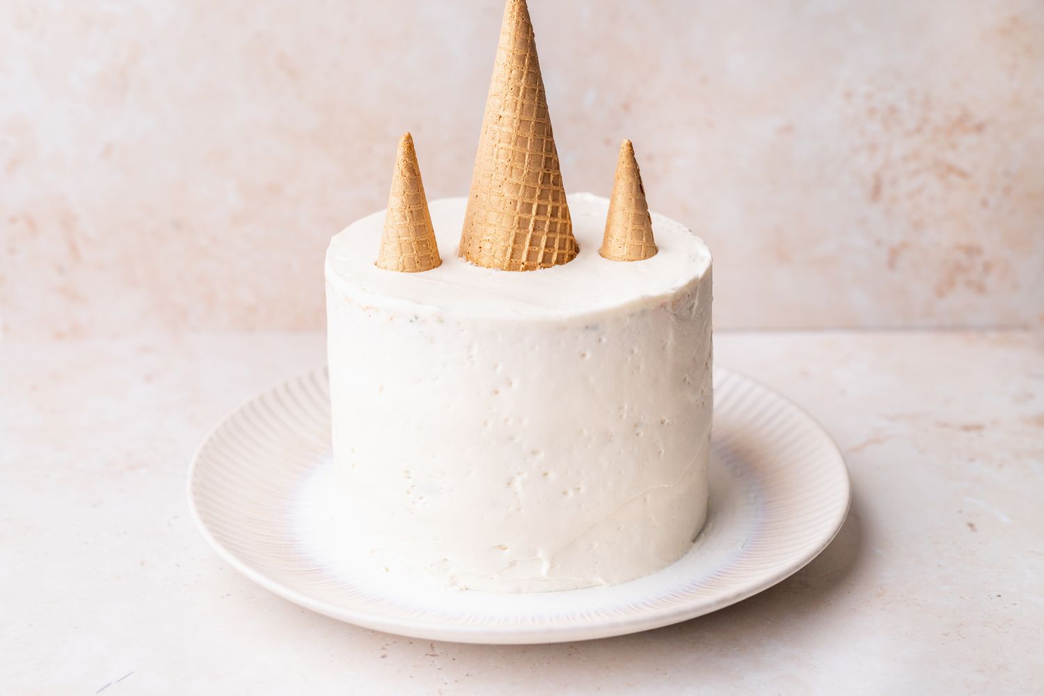 Cones Added to Frosted Unicorn Cake on a Plate 