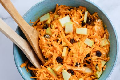 Classic Carrot Salad in a bowl with wooden serving spoons.