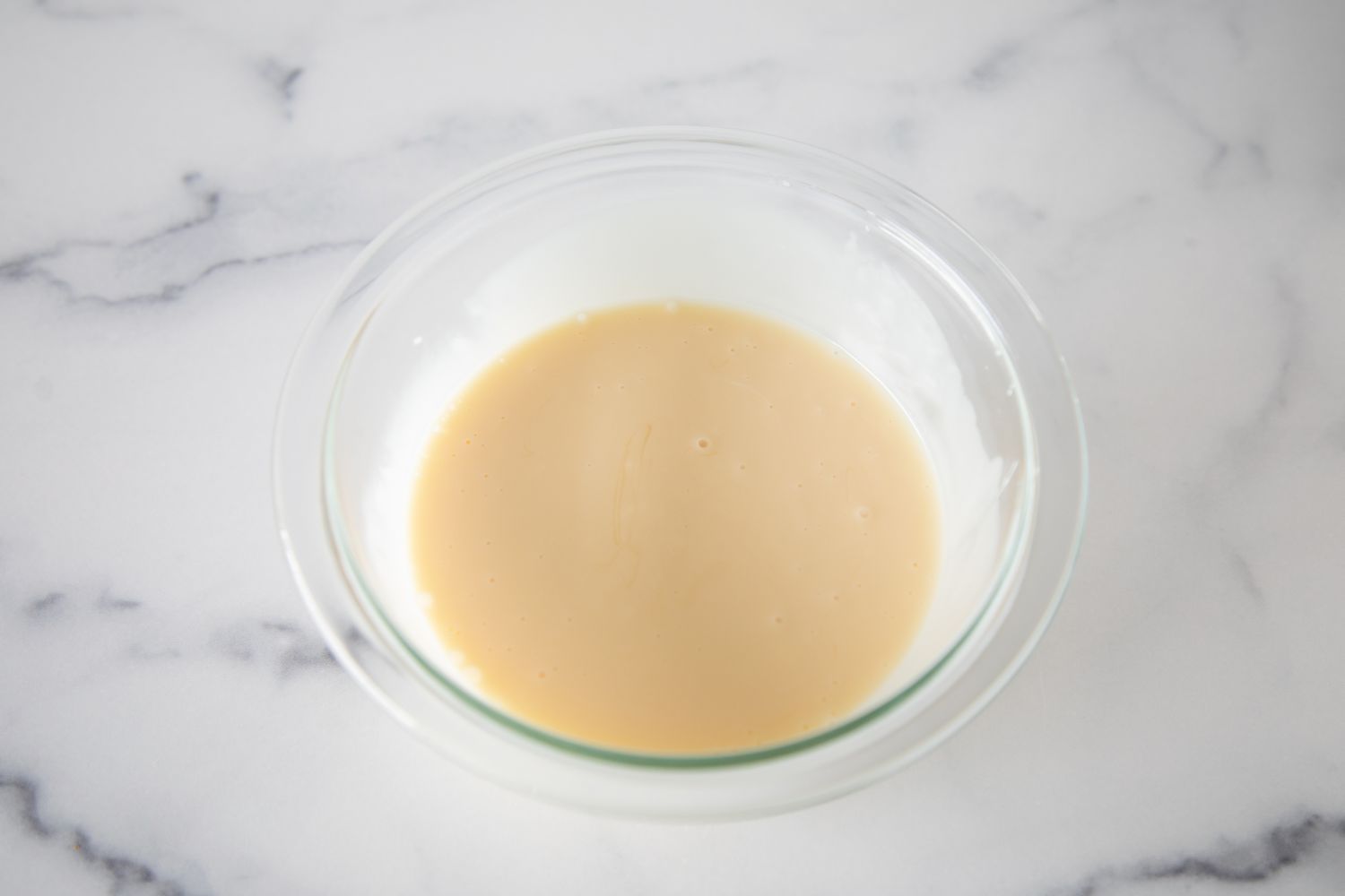 A bowl with a mayo dressing for Broccoli Salad