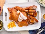 Citrus-brined smoked turkey carved on a platter.